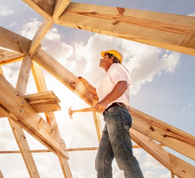 roofer builder working on roog structure of building on construction site